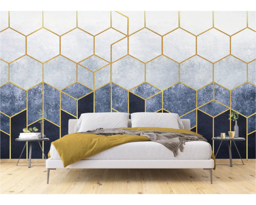 Ein Schlafzimmer mit einer Tapete mit goldenen geometrischen Formen hinter einem Bett