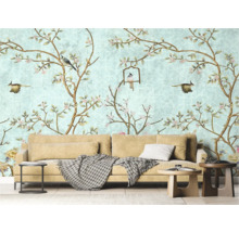 Wohnzimmer mit Tapete mit Vogel- und Blumenmuster, Sofa und Beistelltischen.