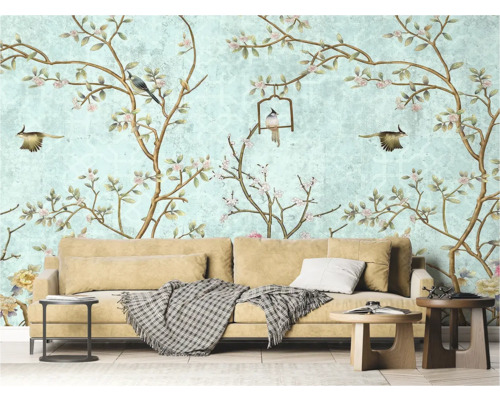 Wohnzimmer mit Tapete mit Vogel- und Blumenmuster, Sofa und Beistelltischen.