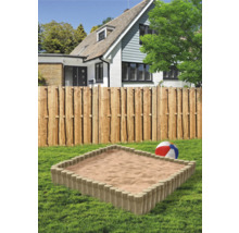 Sandkasten im Garten mit Holzzaun und Wohnhaus