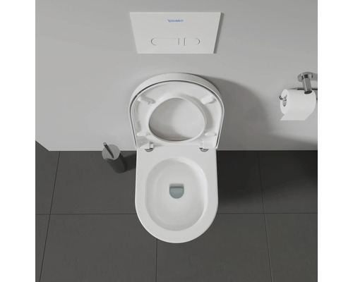 Aufnahme einer Toilette mit offenem Toilettendeckel, Spülkasten, Toilettenpapier und Toilettenbürste.
