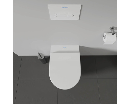 Aufnahme von oben einer Toilette mit Betätigungsplatte, Toilettenpapierhalter und Toilettenbürste
