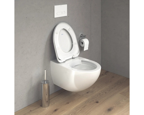 Wand-Tiefspül-WC mit offenem Spülrand, Betätigungsplatte, Toilettenbürste und Toilettenpapierhalter im Badezimmer