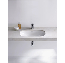Modernes Badezimmer mit Aufsatzwaschbecken, Armatur und Pflegeprodukten auf einer Ablage.