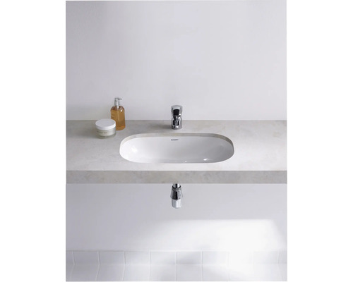 Modernes Badezimmer mit Aufsatzwaschbecken, Armatur und Pflegeprodukten auf einer Ablage.