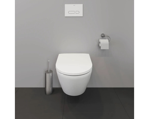 Wandhängendes WC mit Betätigungsplatte, Toilettenbürste und Toilettenpapierhalter in einem Badezimmer