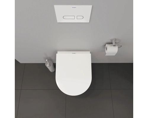 Badezimmer mit Toilette, Betätigungsplatte, Toilettenbürste und Toilettenpapierhalter