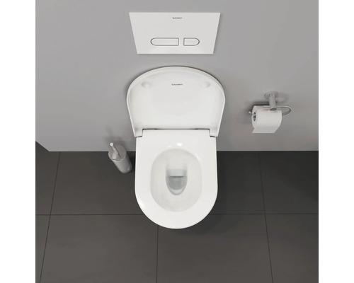 Aufnahme von oben einer Toilette mit offenem Deckel, Toilettenbürste, Toilettenpapierhalter und Betätigungsplatte