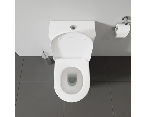 Aufnahme von oben einer Toilette mit Toilettenpapierhalter und Toilettenbürste