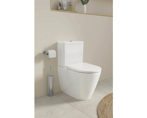 Weißes Stand-WC mit Toilettenpapierhalter und Toilettenbürste im Badezimmer