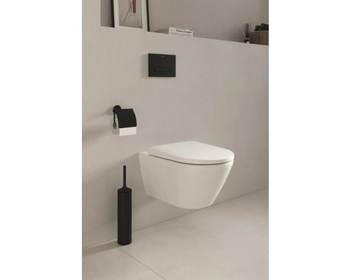 Wandhängendes WC mit Toilettenbürste, Toilettenpapierhalter und Betätigungsplatte in einem Badezimmer