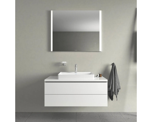 Badezimmer mit Waschbecken, Unterschrank und beleuchtetem Spiegel