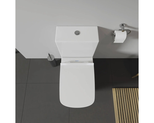 Aufnahme von oben einer Toilette mit Toilettenbürste und Toilettenpapierhalter.