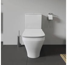 Weisse Toilette mit Toilettenbürste und Toilettenpapierhalter im Badezimmer
