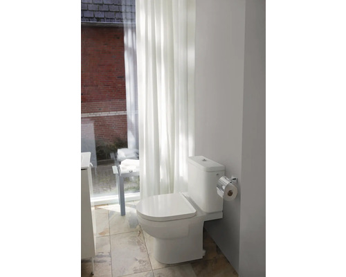 Toilette im Badezimmer mit Vorhängen und Fliesenboden