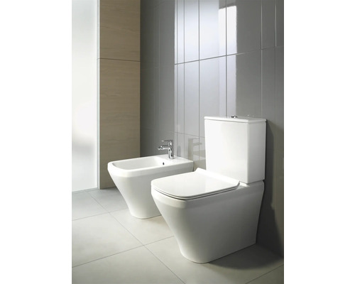 Bidet und Stand-WC im Badezimmer mit grauen Fliesen.