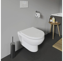 Hänge-WC im Badezimmer mit Toilettenbürste, Toilettenpapierhalter und kleinem Tisch