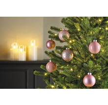 Nahaufnahme eines geschmückten Weihnachtsbaums mit rosa Weihnachtskugeln und Lichterketten.