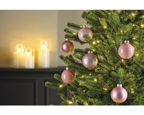 Nahaufnahme eines geschmückten Weihnachtsbaums mit rosa Weihnachtskugeln und Lichterketten.