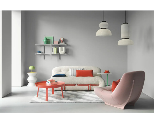 Helles Wohnzimmer mit Sofa, Sessel, Tisch und Regalen