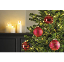Detailaufnahme eines geschmückten Weihnachtsbaums mit roten Weihnachtskugeln und Lichtern