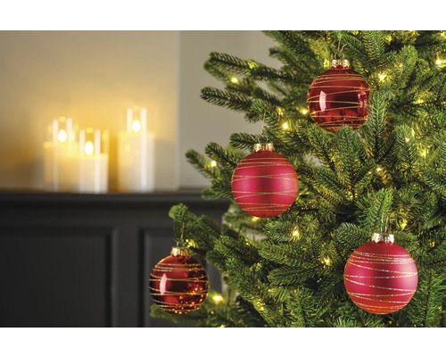 Detailaufnahme eines geschmückten Weihnachtsbaums mit roten Weihnachtskugeln und Lichtern