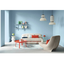 Wohnzimmer mit Sofa, Sessel, Tisch, Regalen und Pendelleuchten