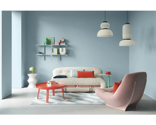 Wohnzimmer mit Sofa, Sessel, Tisch und Regalen in hellem Design