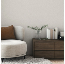 Wohnzimmer mit Sessel, Holzkommode und Büchern