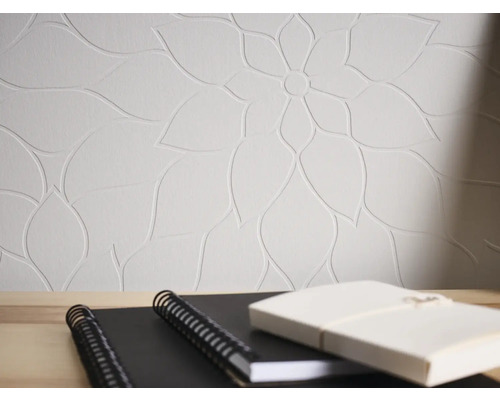 Tapete mit floralem Muster und Notizbücher auf einem Tisch