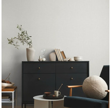 Wohnzimmer mit Kommode, Sessel und gemusterter Tapete