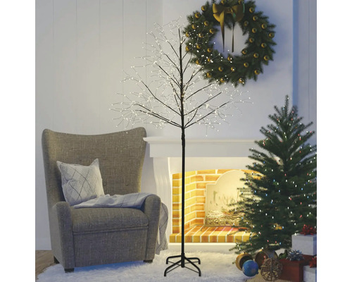 Wohnzimmer mit Sessel, Weihnachtsbaum, Adventskranz und beleuchtetem Dekobaum