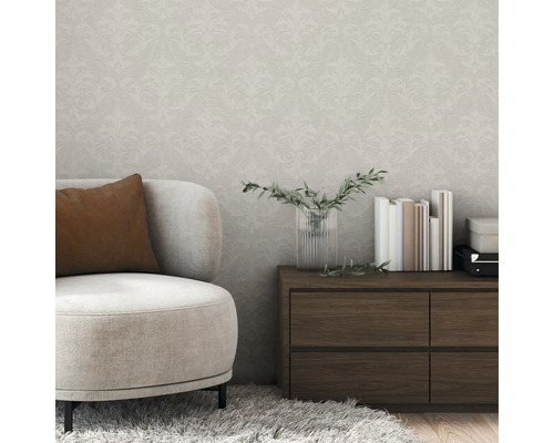 Wohnzimmer mit gemusterter Tapete, Sessel und Kommode