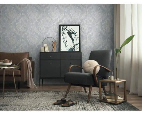 Wohnzimmer mit gemusterter Tapete, Sessel und Kommode