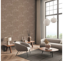 Wohnzimmer mit gemusterter Tapete, Sofa, Sessel und Beistelltischen.