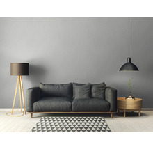 Wohnzimmer mit Sofa, Stehlampe, Pendelleuchte und Beistelltisch auf einem geometrischen Teppich