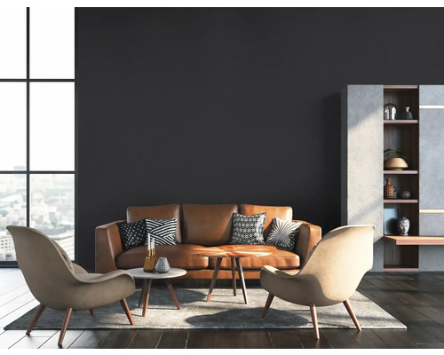Wohnzimmer mit braunem Ledersofa, zwei Sesseln und einem Regal