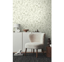 Szene mit floral gemusterter Tapete, Kommode, Sessel und Dekoration