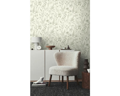 Szene mit floral gemusterter Tapete, Kommode, Sessel und Dekoration