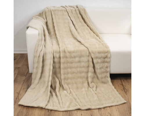 Beige Kuscheldecke auf einem Sofa