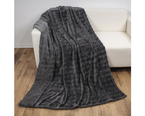 Graue Kuscheldecke auf einem weißen Sofa