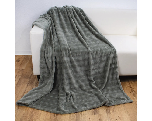Graue Fleecedecke auf einem weißen Sofa