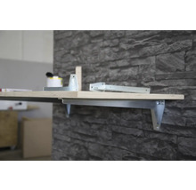 Wandregal mit Metallhalterung und Holzplatte an einer Steinwand