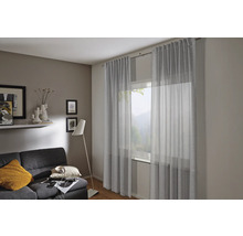 Wohnzimmer mit Gardinen, Sofa und Stehlampe für eine gemütliche Atmosphäre