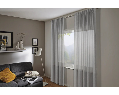 Wohnzimmer mit Gardinen, Sofa und Stehlampe für eine gemütliche Atmosphäre