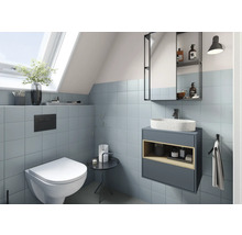 Modernes Badezimmer mit Toilette, Waschtisch und Spiegelschrank unter einem Dachfenster