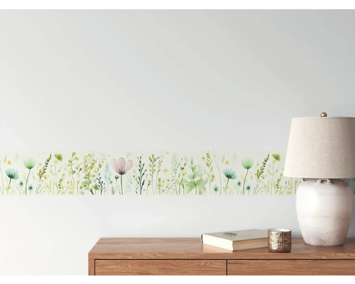 Wandbordüre mit Blumenmuster im Interieur über Kommode, Lampe und Buch