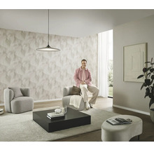 Modernes Wohnzimmer mit gemusterter Tapete, zwei Sesseln, einem Couchtisch und einer Person