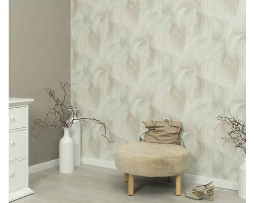 Szene mit gemusterter Tapete, Hocker, Handtasche und Dekoration in einem hellen Raum.