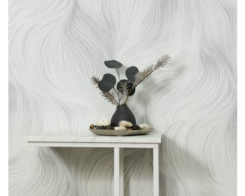 Szene mit einer weißen Tapete mit geschwungenem Muster und einer Tischdekoration mit einer Vase